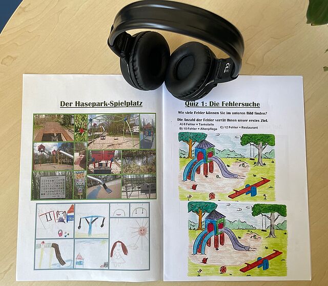 Ein aufgeschlagenes Begleitheft des Projekts mit Kopfhörern