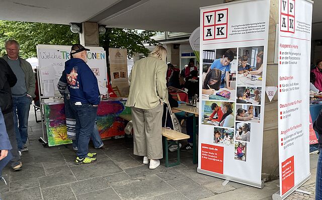 Interessierte Besucher stehen vor unserem VPAK-Stand. 
