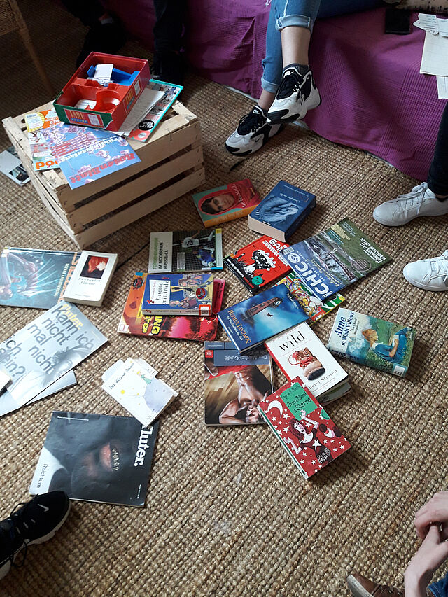 Auf einem Teppich liegen mehrere Jugendbücher.