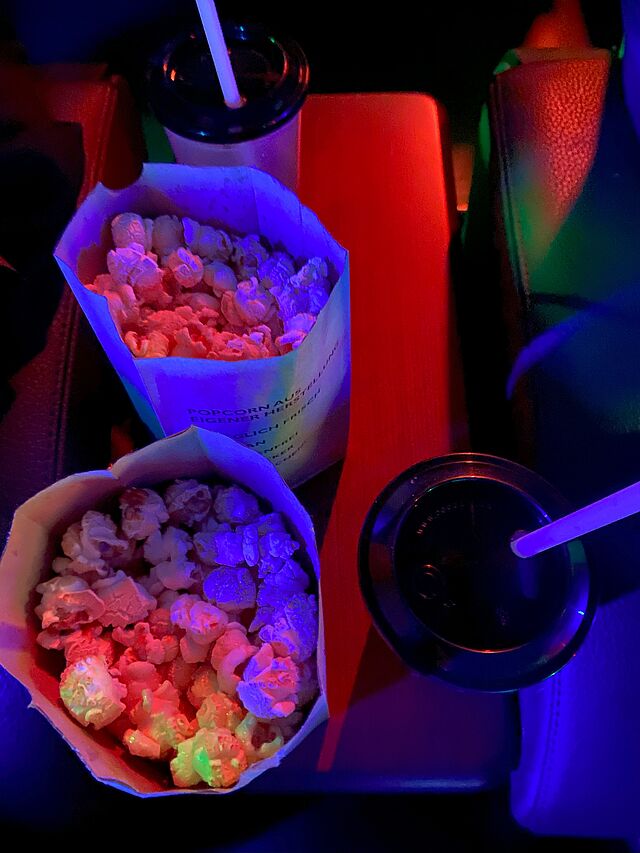 Kinositz mit zwei vollen Popcorntüten.