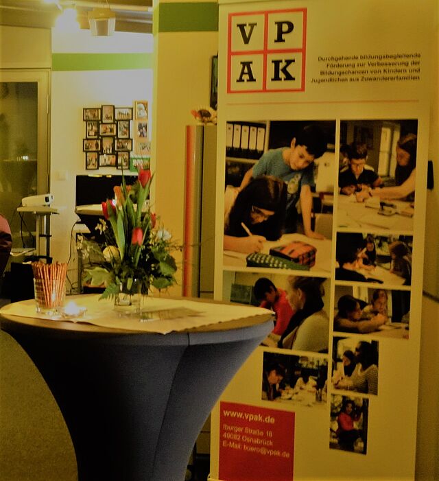 Neujahrsempfang, Stehtisch mit Blumen, im Hintergrund der VPAK-Aufsteller.
