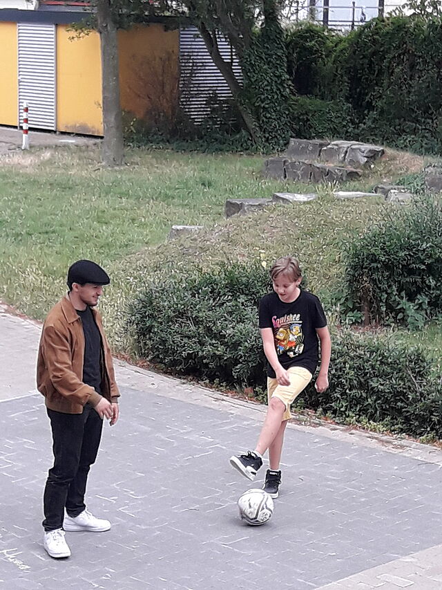 Zwei Jugendliche spielen Fußball.