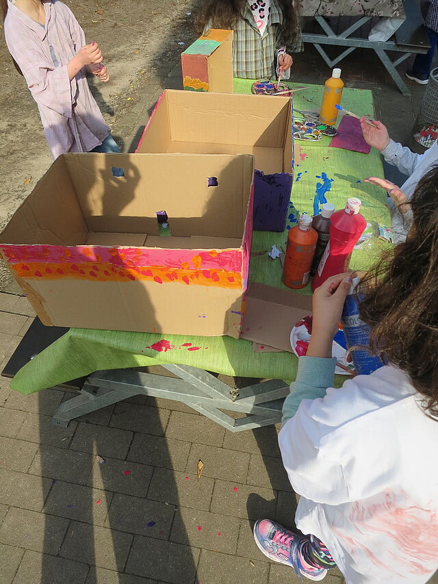 Kinder bemalen mit verschiedenen Farben Kartons