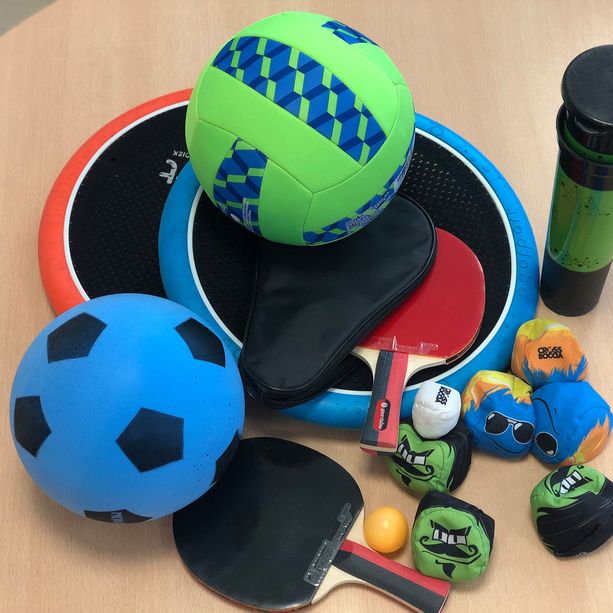 Ein Foto zeigt verschiedene Spielzeuge für Bewegungsangebote, zum Beispiel Bälle, Tischtennisschläger und vieles mehr.