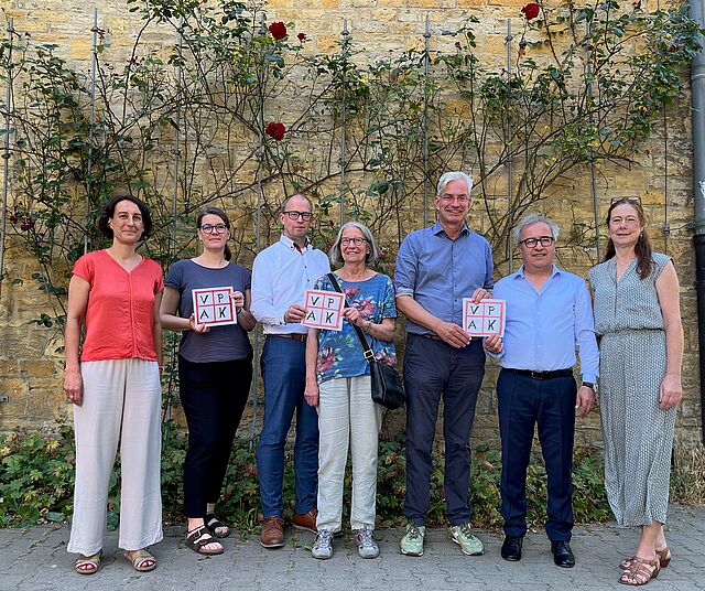 Dr. Middelberg steht mit Mitarbeiterinnen und Vorstandsmitgliedern des VPAK e.V. vor dem Projekt SiebenPlus.