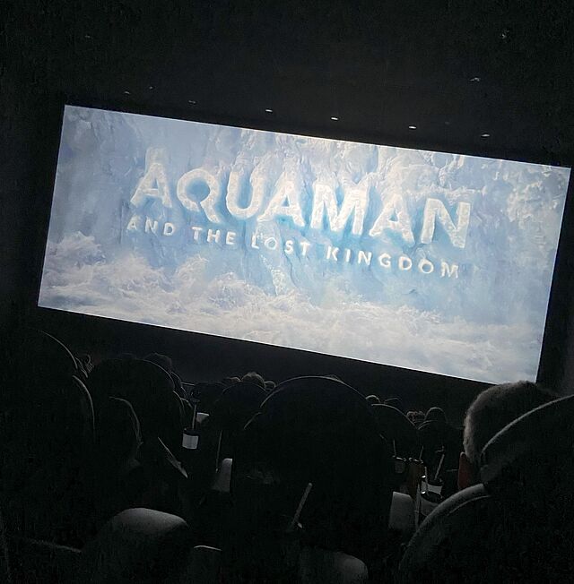Auf der hellen Kinoleinwand steht Aquaman.