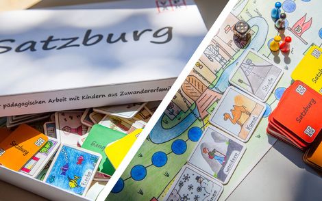 Satzburgkarton und Spielplan mit bunten Kärtchen auf Tisch
