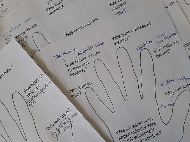 Ausgefüllte Feedbackbögen liegen auf einem Tisch.