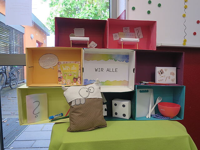 Bunte Kartons mit dem Motto: Wir alle!
