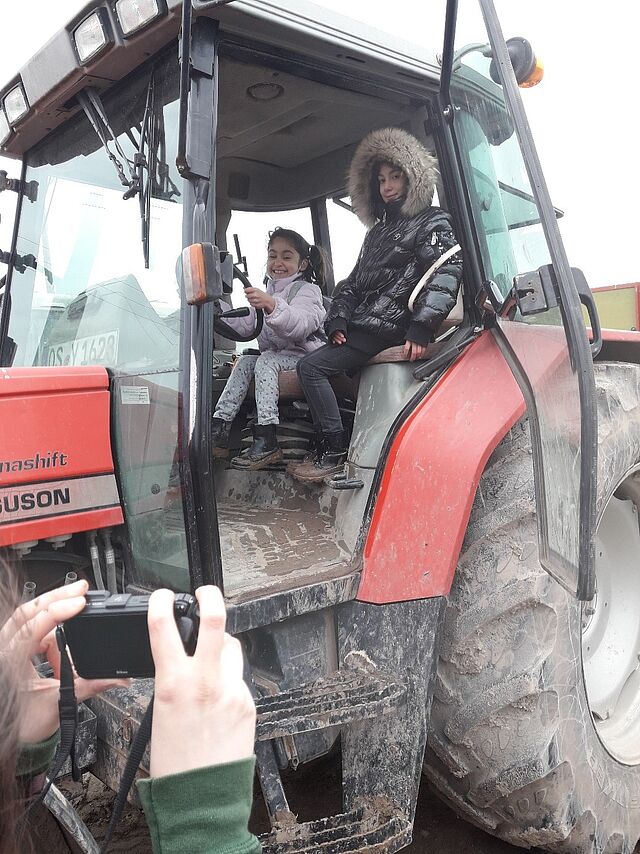 Zwei Kinder sitzen im Traktor