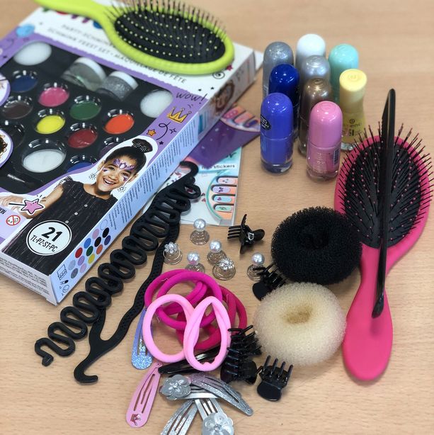 Ein Foto zeigt Material, wie bunte Haarbänder und Nagellack, der AG "Was Mädchen gerne machen".
