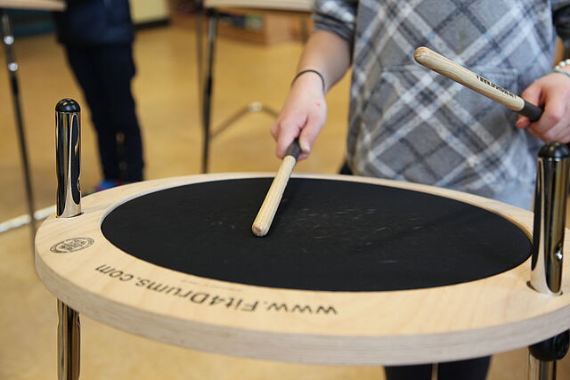 Drumsticks in Kinderhänden in Aktion auf einer Trommel