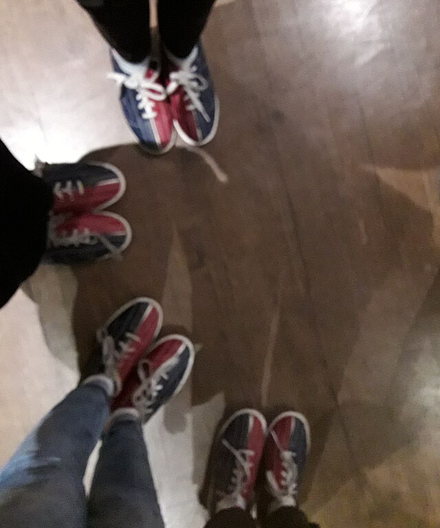 Vier Beinpaare mit Bowlingschuhen.