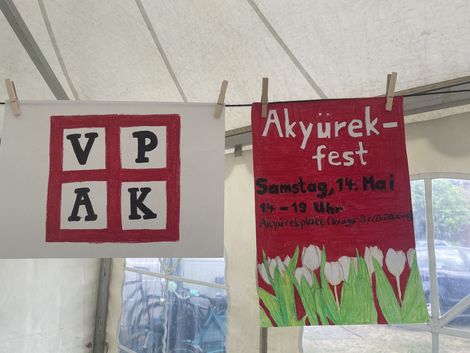 Plakate mit VPAK-Logo und Infos zum Akyürek-Fest.
