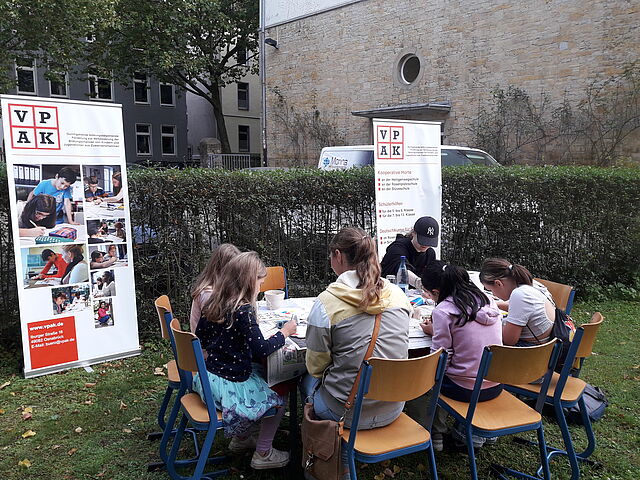 An einem Tisch sitzt eine Kindergruppe und bastelt.
