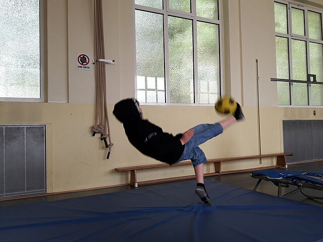 Ein Junge spielt mit einem Ball.