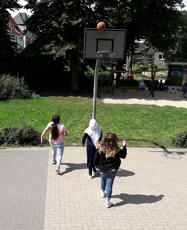 Drei Mädchen spielen Basketball